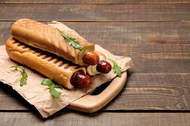 Hot dog francesi. Gustosi hot dog sulla tavola su un tavolo di legno marrone. cibo di strada veloce. salsicce in un panino.