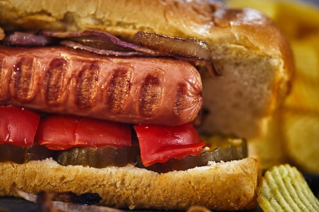 Hot dog - Salsiccia calda nidificata in un panino con cetrioli, peperoncino e cipolle