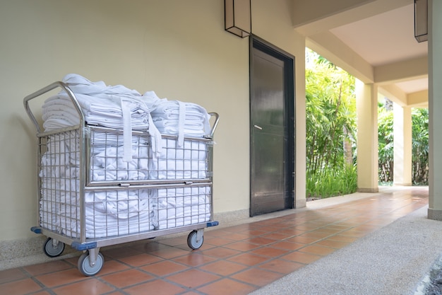 Hotel cameriera carrello parcheggio davanti alla camera con asciugamani puliti e accappatoi pronti per cambiarsi e rifare la camera.