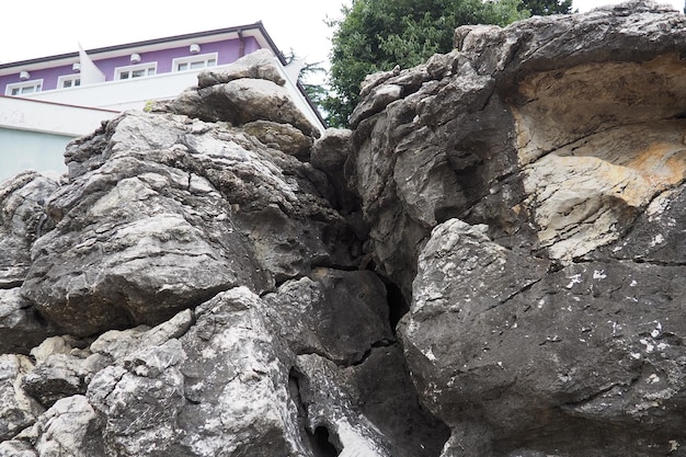 Hotel casa sul bordo di una lava vulcanica indurita roccia Herceg Novi Montenegro Una grande fessura nella roccia una grotta Strati in una roccia Geologia e sismologia nella regione mediterranea adriatica