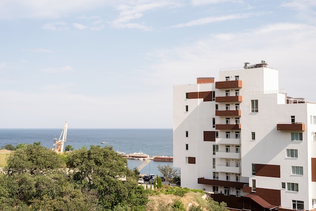 Hotel moderno o condominio in riva al mare. Bellissimo paesaggio estivo sul mare, porto per barche