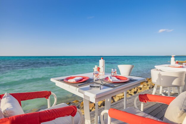 Hotel resort di lusso sull'acqua, ristorante all'aperto sulla spiaggia, oceano e cielo, vista sul mare Tropicale