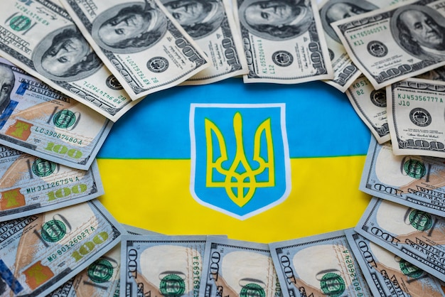 Hryvnia valuta ucraina e dollaro americano sullo sfondo della bandiera ucraina Assistenza statale ai cittadini in relazione alla guerra in Ucraina