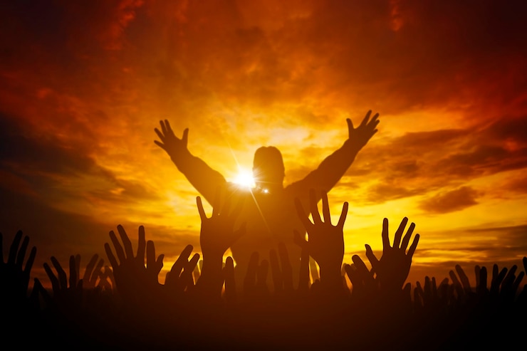 Human raised hands for worship God over amazing light of sunset background