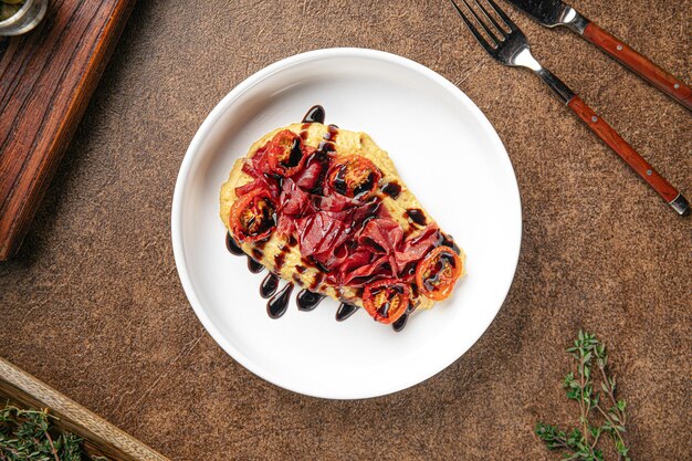 Hummus con bresaola e porzione di pomodoro