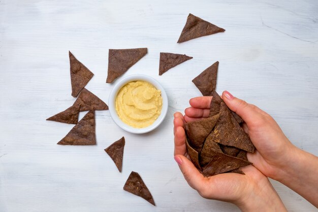 Hummus con pane di segale su sfondo bianco.