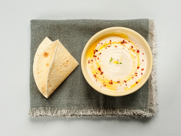 Hummus con tortillas di taco sul grigio.