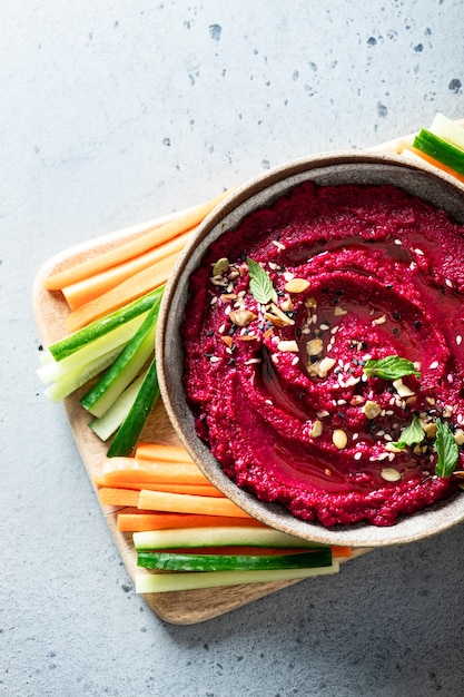 hummus di barbabietola in una ciotola di ceramica su uno sfondo chiaro, vista dall'alto