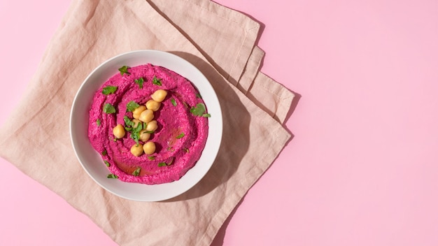 Hummus di barbabietola su sfondo rosa vista dall'alto