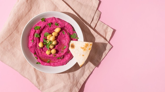 Hummus di barbabietola su sfondo rosa vista dall'alto