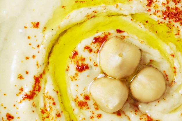 Hummus di ceci decorato con ceci lessati, olio d&#39;oliva e paprika.