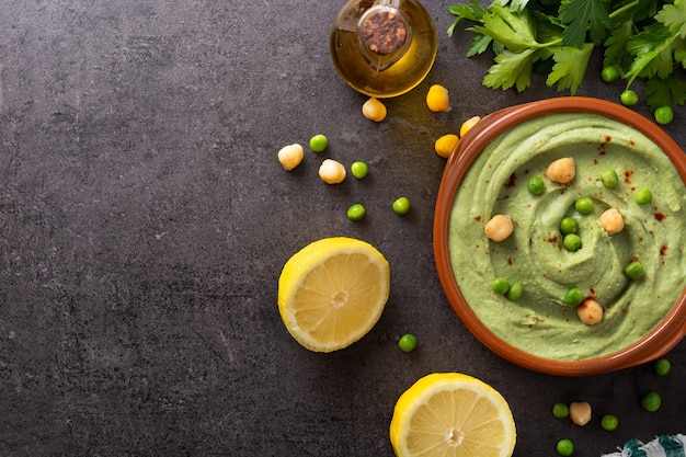 Hummus di piselli verdi su tavola di ardesia nera