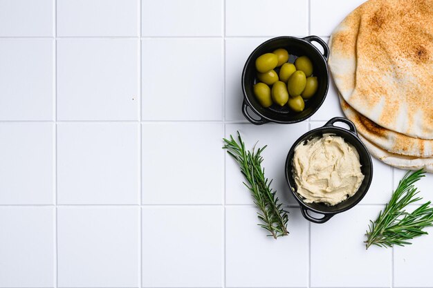 Hummus e pane pita impostato su ceramica bianca piastrella quadrata sfondo tavolo vista dall'alto piatto con copia spazio per il testo
