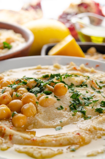 Hummus fresco fatto in casa in un piatto di argilla condito con ceci all'olio d'oliva