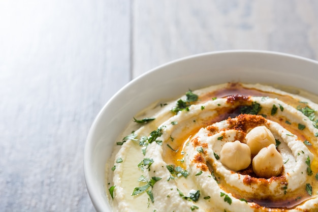 Hummus in ciotola su una tavola di legno rustica