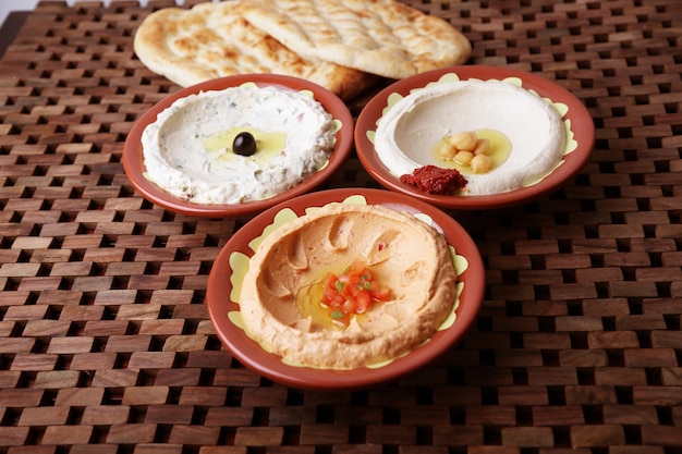 Hummus misto con pane servito in un piatto isolato sulla vista laterale del tavolo del cibo mediorientale