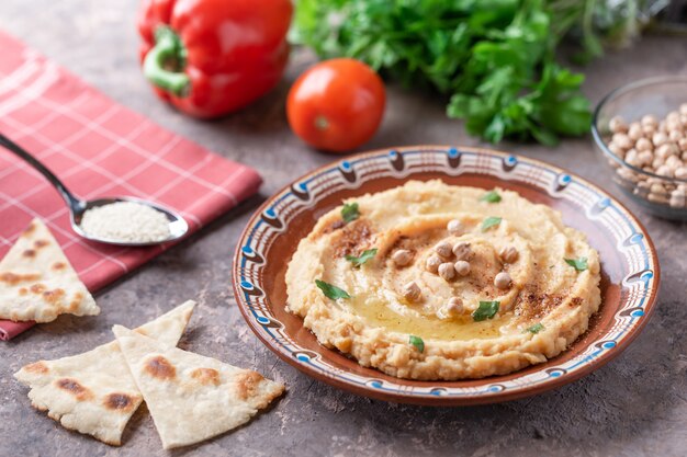 Hummus nel piatto di argilla marrone