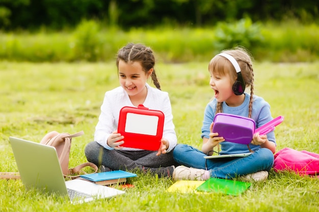 i bambini al picnic nel cortile della scuola stanno venendo a mangiare il pranzo nella scatola. genitore si occupa della custodia dei figli.