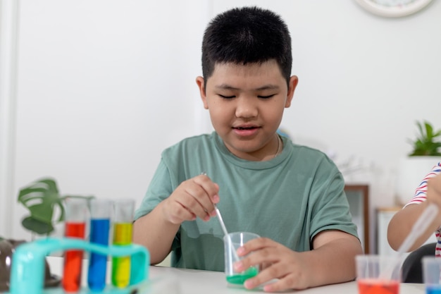I bambini asiatici osservano con entusiasmo gli esperimenti di chimica