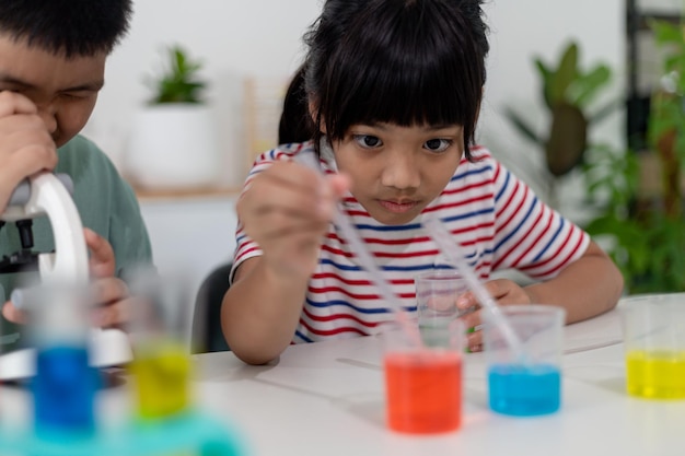 I bambini asiatici osservano con entusiasmo gli esperimenti di chimica