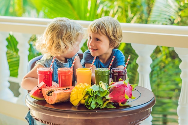 I bambini bevono frullati colorati e salutari, anguria, papaia, mango, spinaci e frullati di frutta del drago