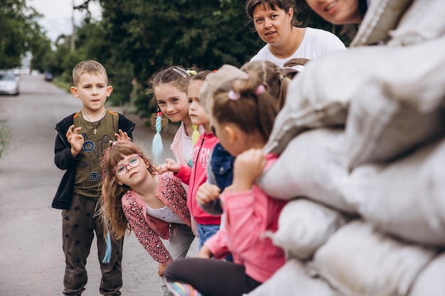 i bambini camminano in coppia e si nascondono in un posto di blocco fatto di sacchi di sabbia durante un allarme antiaereo