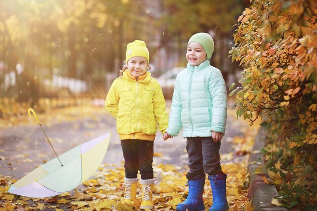 I bambini camminano nel parco autunnale in autunno