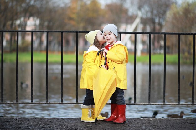 I bambini camminano nel parco autunnale in autunno