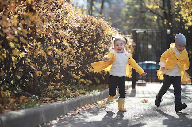 I bambini camminano nel parco autunnale in autunno