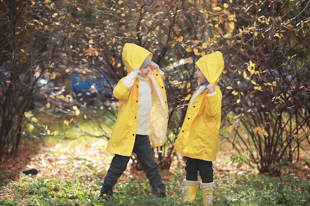 I bambini camminano nel parco autunnale in autunno