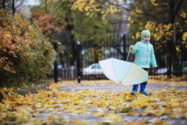 I bambini camminano nel parco autunnale in autunno