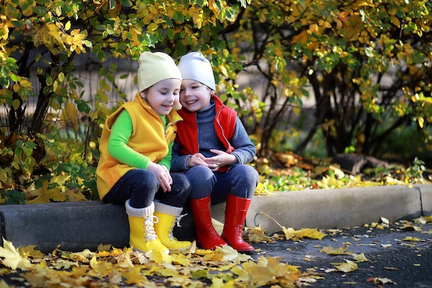 I bambini camminano nel parco autunnale in autunno