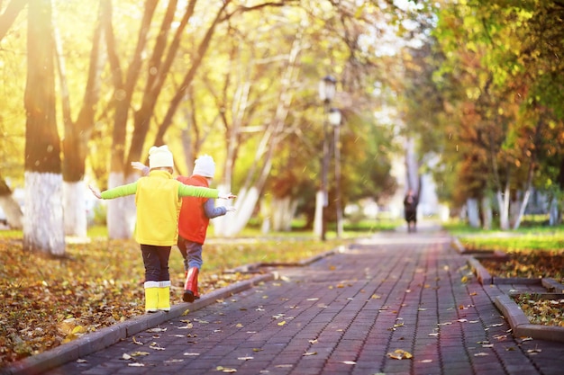 I bambini camminano nel parco autunnale in autunno