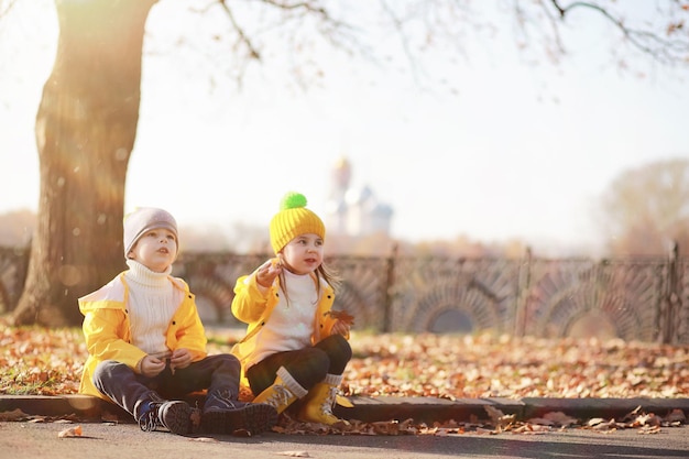 I bambini camminano nel parco autunnale in autunno