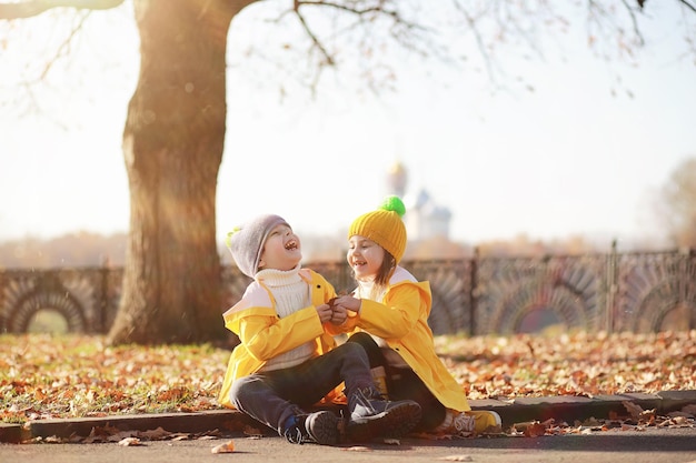 I bambini camminano nel parco autunnale in autunno