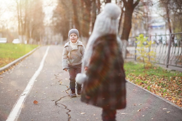 I bambini camminano nel parco autunnale in autunno