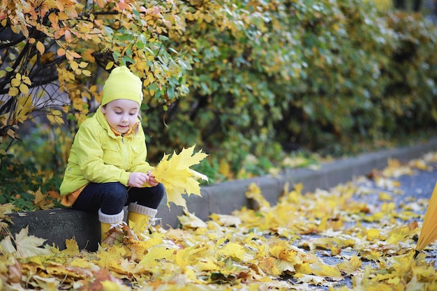 I bambini camminano nel parco autunnale in autunno