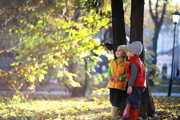 I bambini camminano nel parco autunnale in autunno