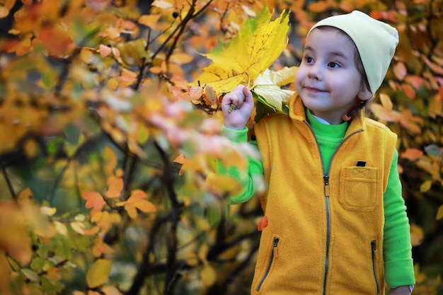 I bambini camminano nel parco autunnale in autunno