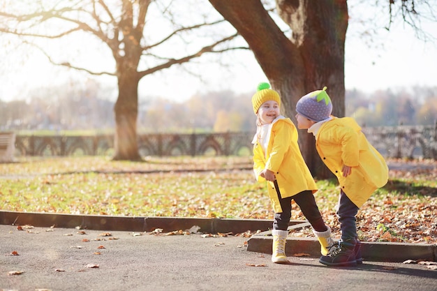 I bambini camminano nel parco autunnale in autunno