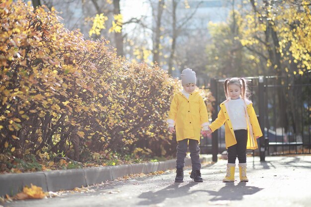 I bambini camminano nel parco autunnale in autunno