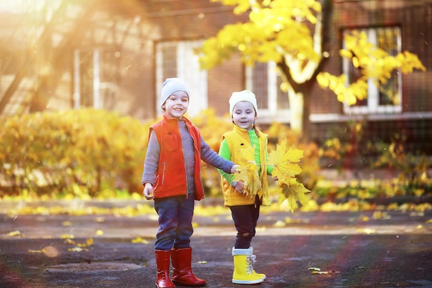 I bambini camminano nel parco autunnale in autunno