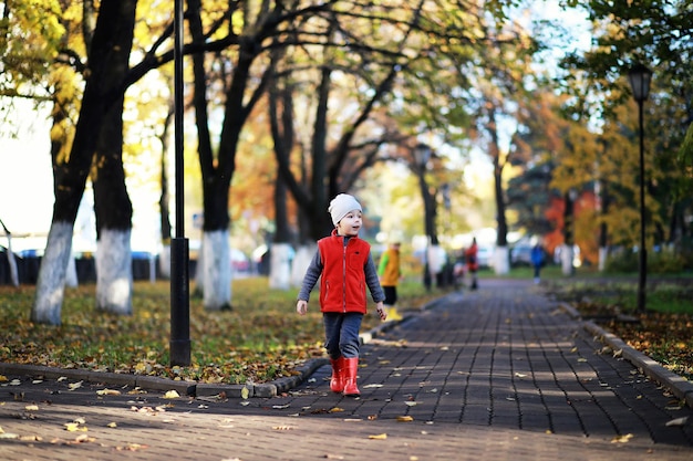 I bambini camminano nel parco autunnale in autunno