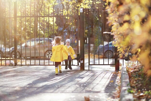 I bambini camminano nel parco autunnale in autunno