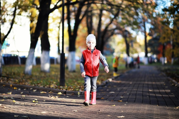 I bambini camminano nel parco autunnale