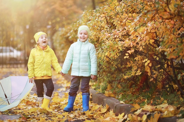 I bambini camminano nel parco autunnale