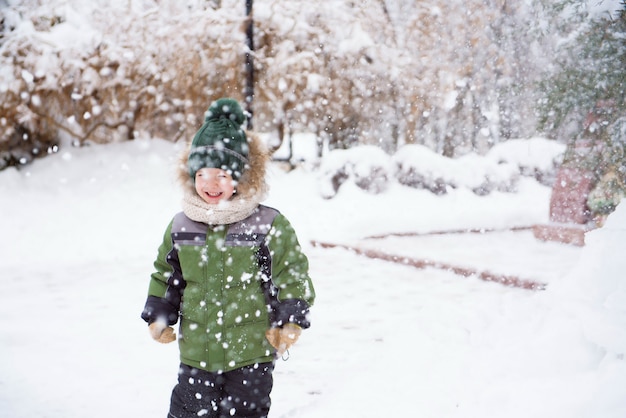 I bambini camminano nel parco con la prima neve