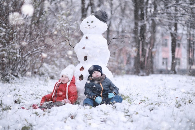 I bambini camminano nel parco con la prima neve