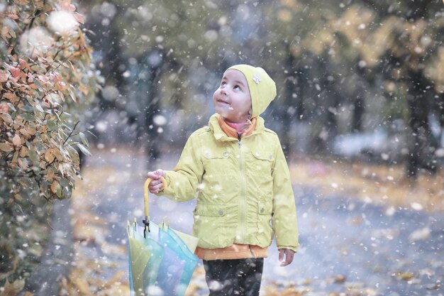 I bambini camminano nel parco con la prima neve