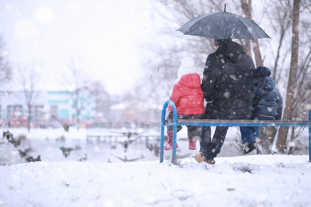 I bambini camminano nel parco con la prima neve